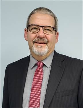 A person wearing glasses and a suit
Description automatically generated with medium confidence